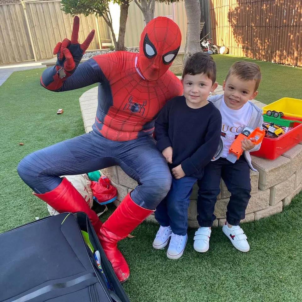 Spider-Man party entertainer throwing peace sign with two young boys in a Melbourne backyard kids birthday party