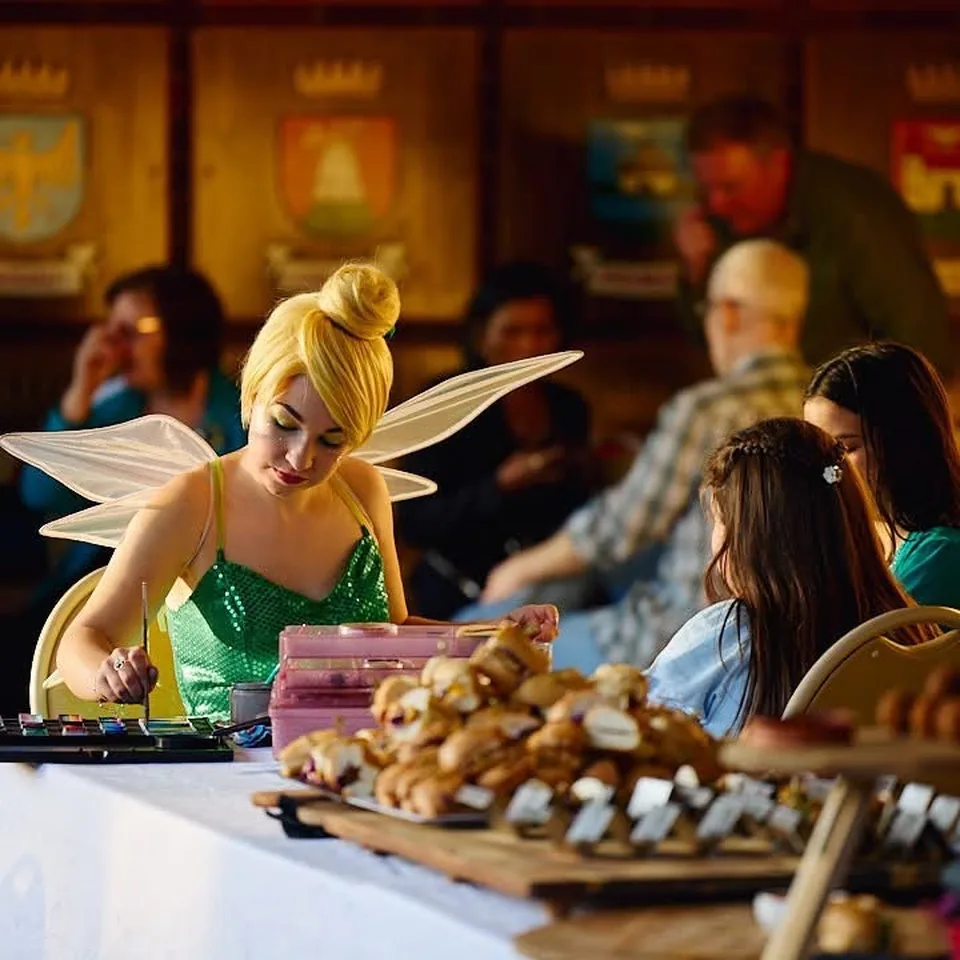 Tinkerbell fairy party entertainer with blonde bun and shimmering wings face painting at a Melbourne community market event