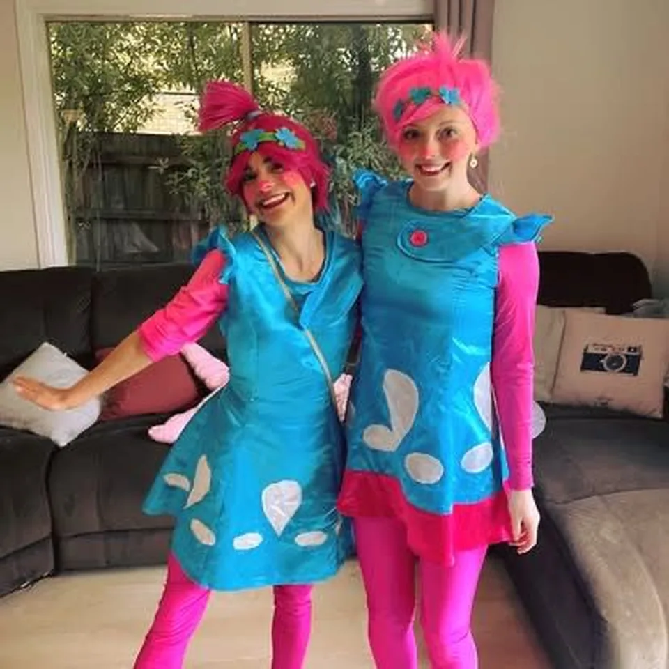 Trolls Poppy and Branch party entertainers with bright pink hair in matching blue Trolls outfits posing for a Melbourne Trolls themed kids birthday party
