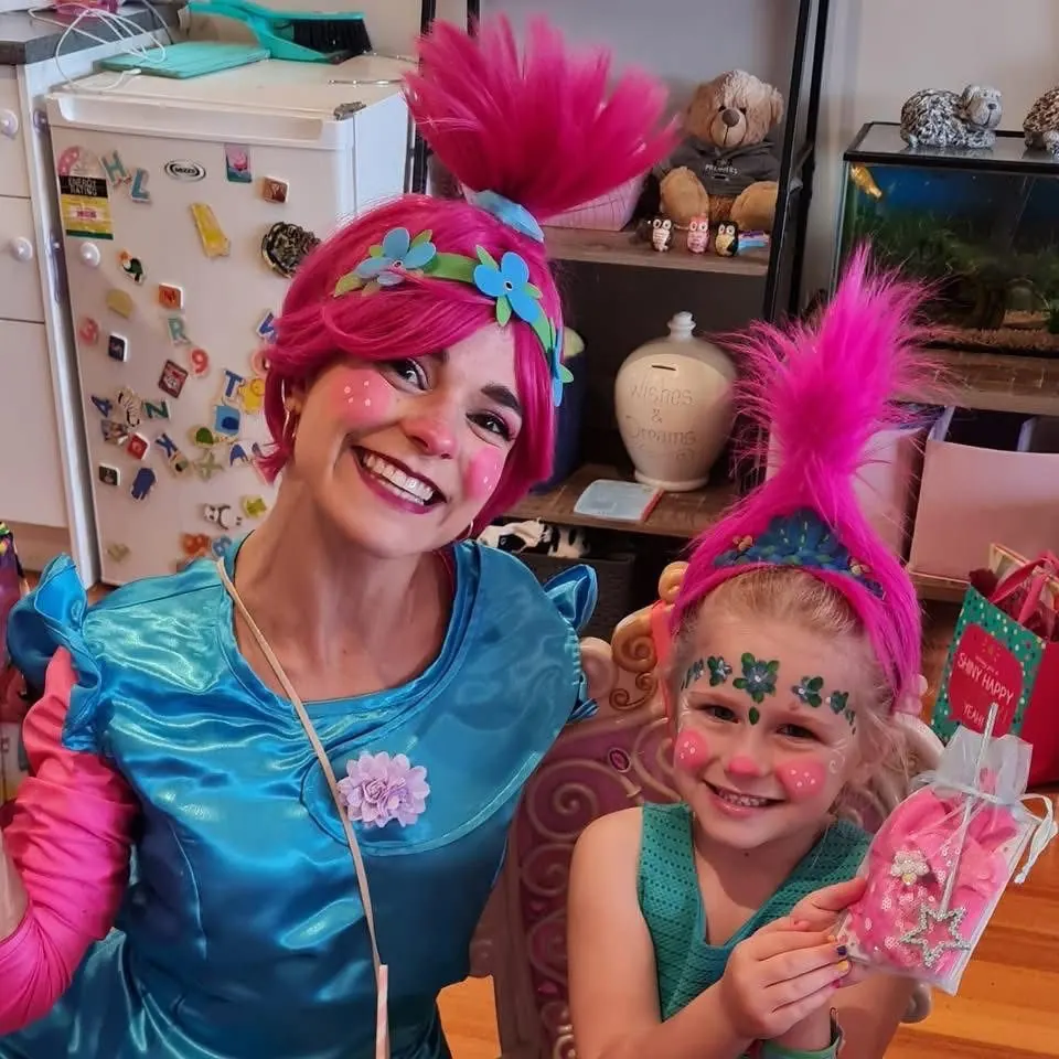 Trolls Princess Poppy party entertainer with pink hair posing with young girl in matching Poppy wig and floral face paint at a Melbourne Trolls birthday party