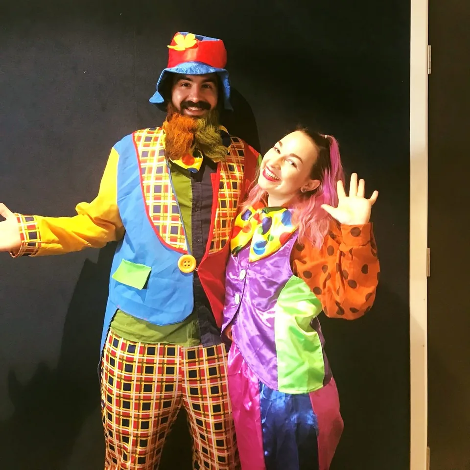 Bubbles the Clown duo party entertainers in matching colourful patchwork costumes, plaid vests and bright hats waving and smiling at a Melbourne kids birthday clown show