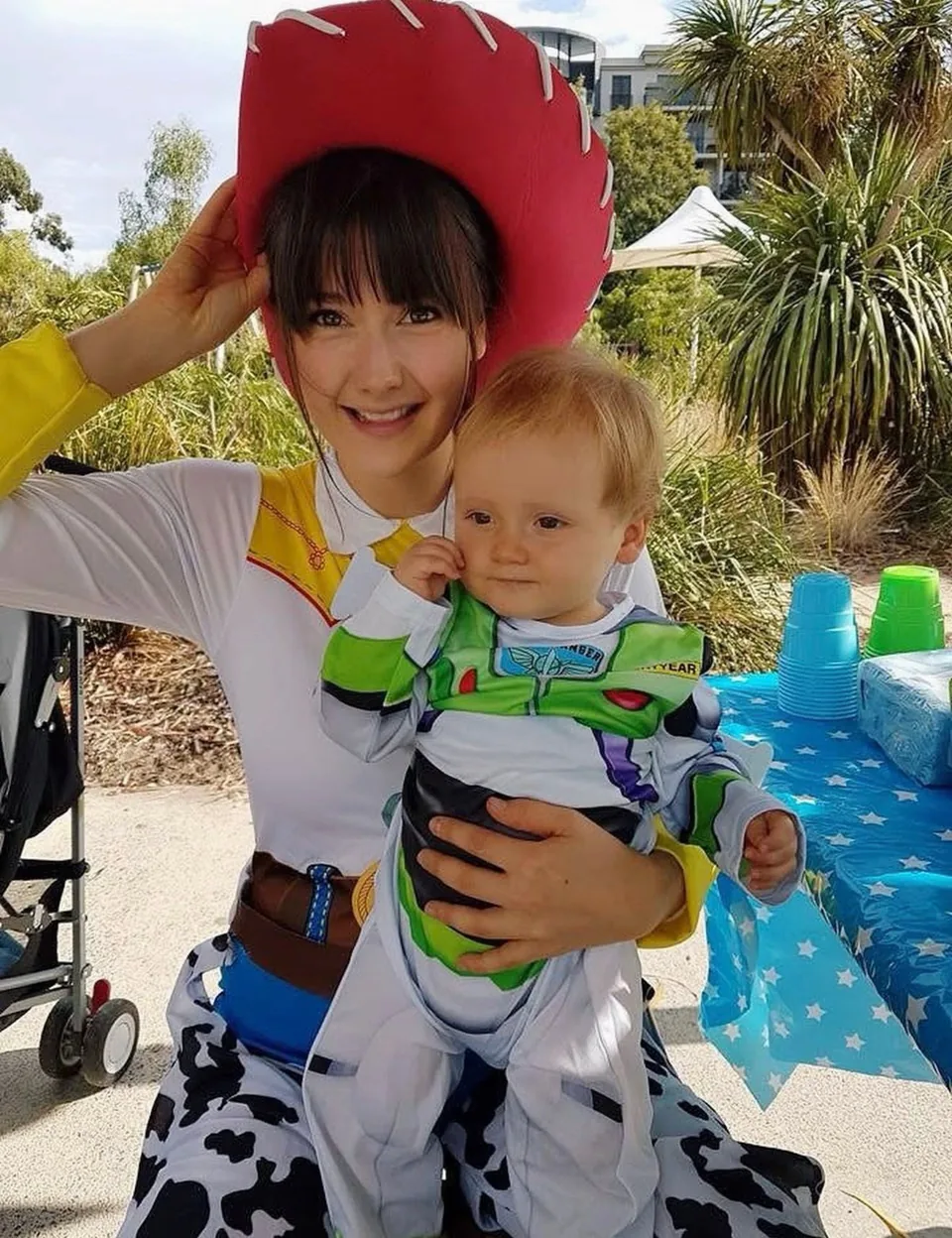 Toy Story Jessie cowgirl party entertainer in red hat cuddling baby boy dressed as Buzz Lightyear at a Melbourne Toy Story themed first birthday party